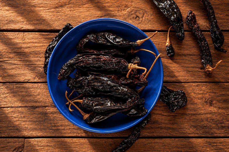 Długie ciemne suszone chilli w niebieskiej misce
