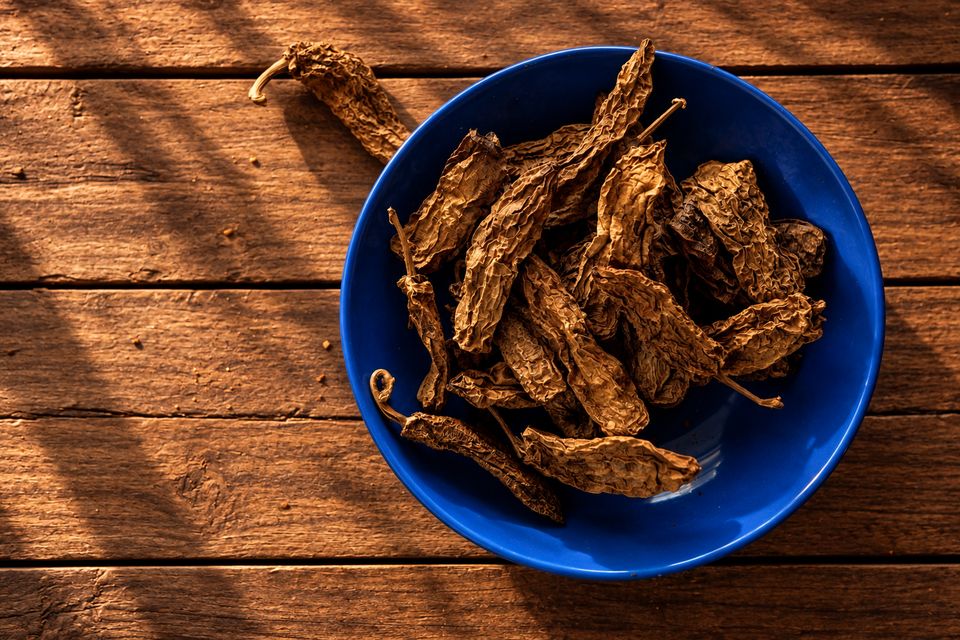 Wędzone brązowe suszone chilli w niebieskiej misce